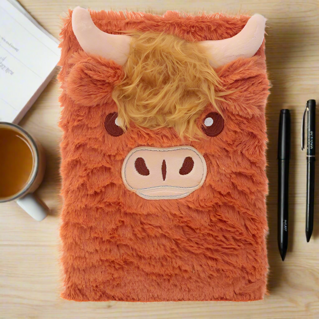 Fluffy highland cow notebbok on table