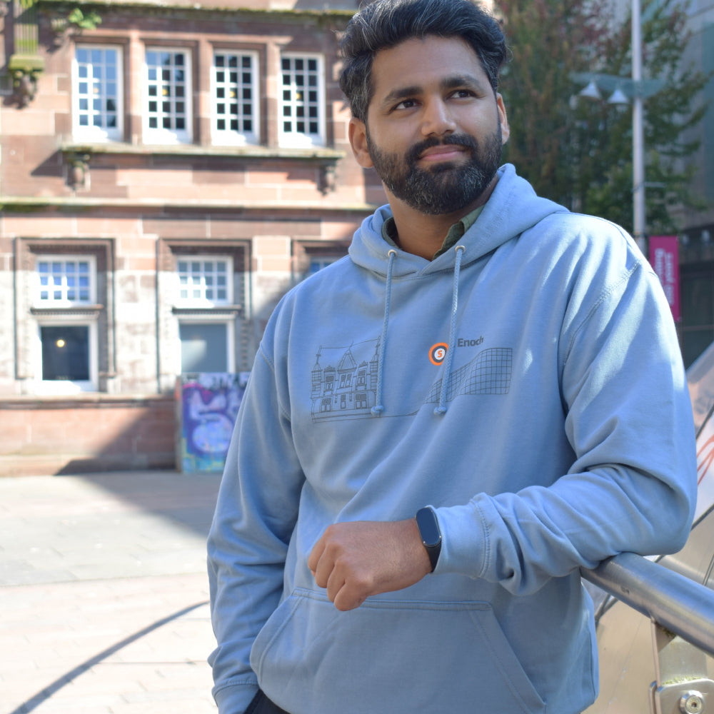 Man wearing blue hoodie standing in front building