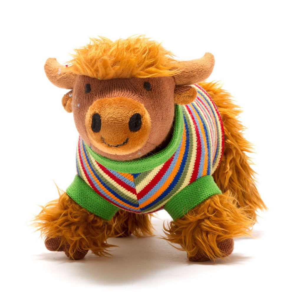 A plush toy resembling a Highland cow with a ginger brown color and a striped multicolored jumper.