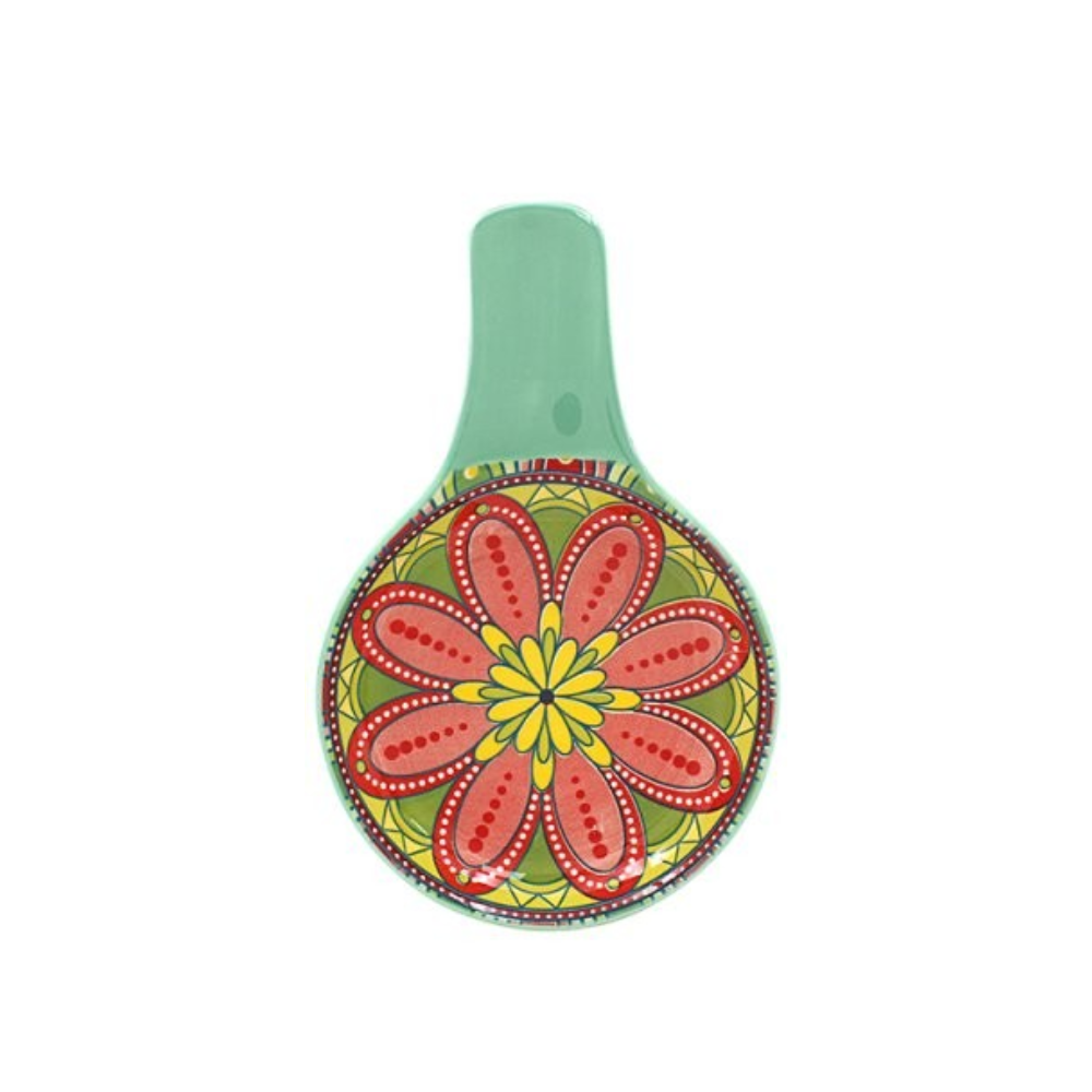 Colorful floral design on a round object with a green handle against a white background