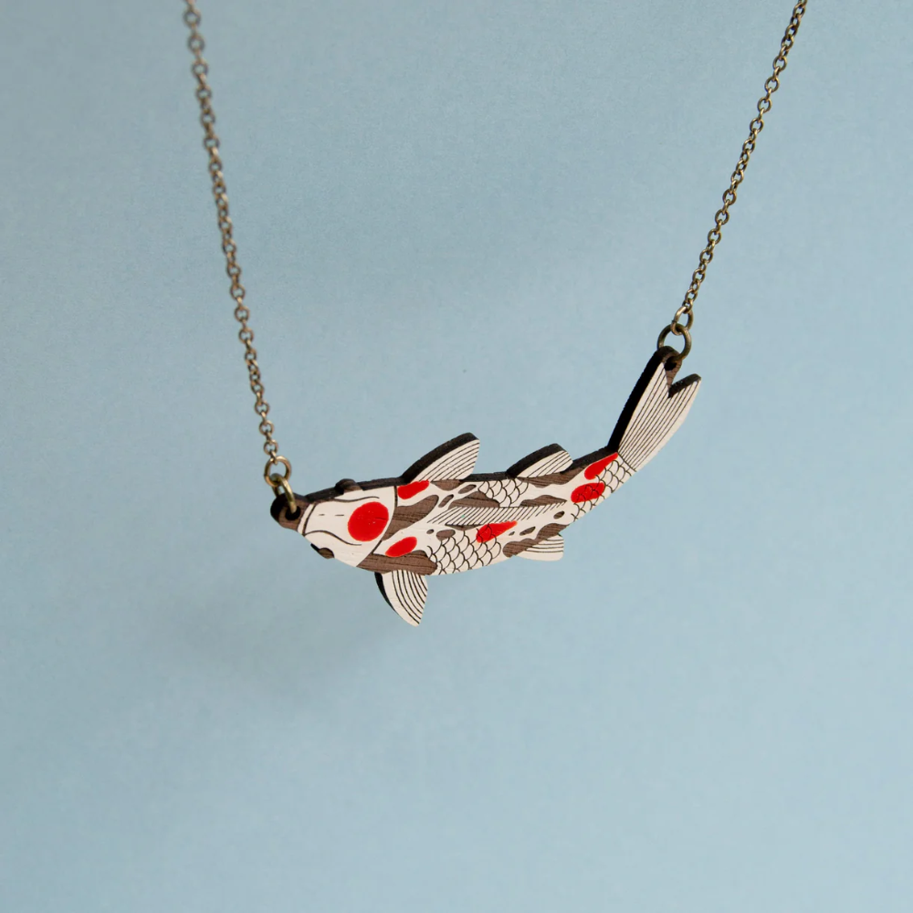 Koi fish pendant necklace on a light blue background